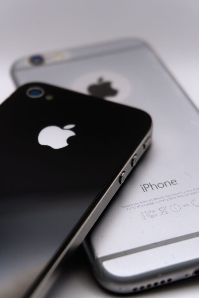 Detailed shot of two smartphones featuring the Apple logo, showcasing modern technology design.
